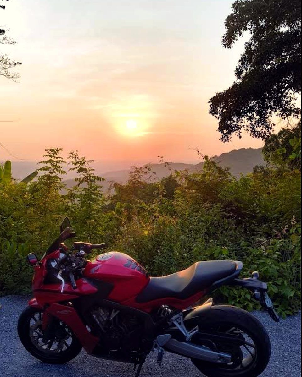 Red Honda CB650F at a mountain viewpoint at sunset